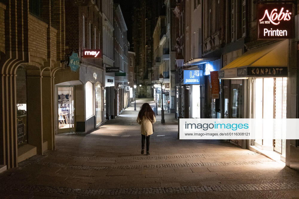 Like an abandoned city. Aachen on Easter vigil between 10 p.m. and 11 p.m. Glance into the deserted Krämerstrasse. A single woman walks through the pedestrian zone. In Aachen on April 3, 2021. GERMANY - AACHEN - EASTER Easter 2021 Covid Pandemic