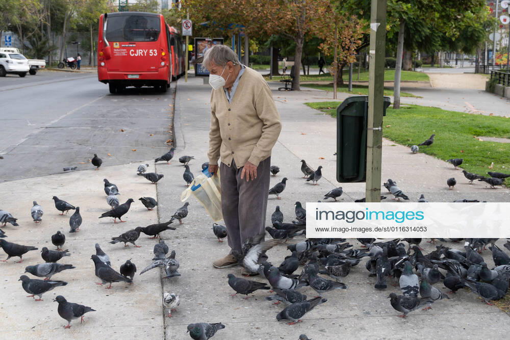 A man with a mask feeds pigeons, amid the total quarantine decreed last week for the Metropolitan Region. Santiago Chile - ZUMAb332 20210404_zip_b332_036