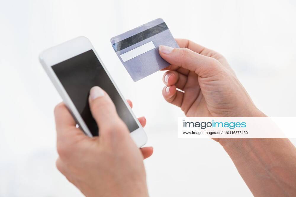 Hands of woman holding smartphone and credit card Hands of woman holding smartphone and credit card on white background, model released, Cape Town, South Africa, 02.10.2014, 432253.jpg, hands, using, smartphone, mobile phone, wireless technology, phone, communication, connection, device, calling, on the phone, phoning, phone call, debit card, credit card, shopping, holding 30s, Mid Adult, Woman, Female, Caucasian, 35-39 Years, Mid Adult Women, Caucasian Ethnicity Indoors,Day