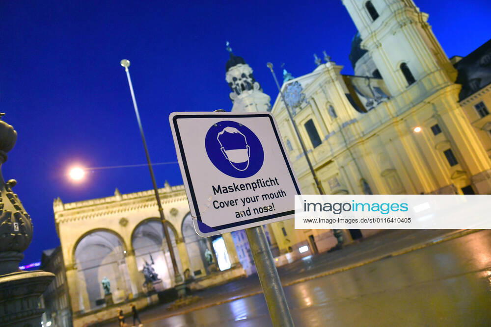 Theme image Is the bridge lockdown coming to break the third wave Deserted Odeonsplatz in Munich with Feldherrnhalle and Theatiner church Sign Maskenpflicht in den Fussgaengerzonen in Muenchen on 06 04 2021 Ausgangssperre,Ausgangsbeschraenkung,Nachtaufnahme,
