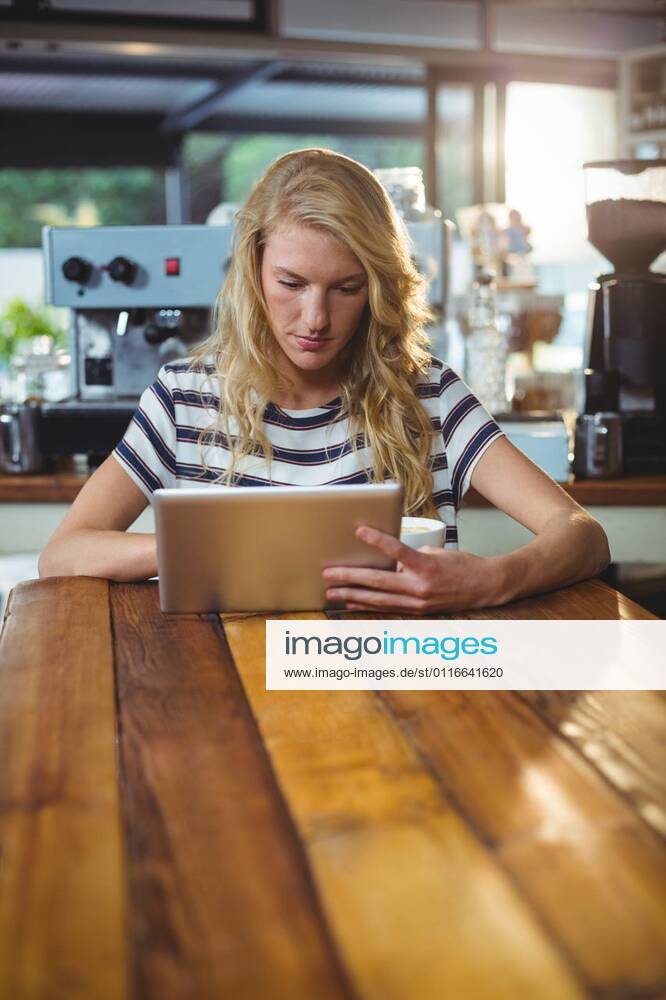 Woman sitting in a cafe using digital tablet Thoughtful woman sitting in a cafe using digital tablet, model released, , property released, Cape Town, South Africa, 30.05.2016, 797480.jpg, table, cafe, coffee shop, cafeteria, restaurant, hotel, casual clothing, sitting, holding, serious, thoughtful, web, internet, touching, reading, scrolling, digital tablet, tablet computer, tablet pc, touchscreen, wireless technology, communication, connection, lifestyle, leisure, pretty, attractive Indoors,Day