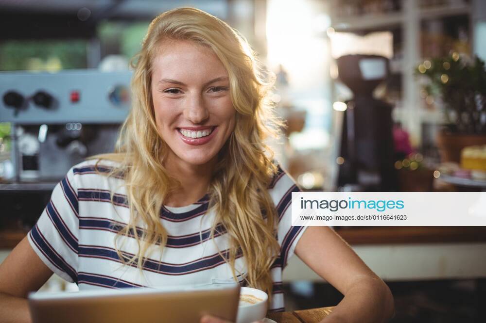 Woman sitting in a cafe using digital tablet Portrait of woman sitting in a cafe using digital tablet, model released, , property released, Cape Town, South Africa, 30.05.2016, 797483.jpg, table, cafe, coffee shop, cafeteria, restaurant, hotel, casual clothing, sitting, holding, smiling, cheerful, web, internet, touching, reading, scrolling, digital tablet, tablet computer, tablet pc, touchscreen, wireless technology, communication, connection, happy, lifestyle, leisure, pretty, attractive Indoors,Portrait,Looking at camera,Day