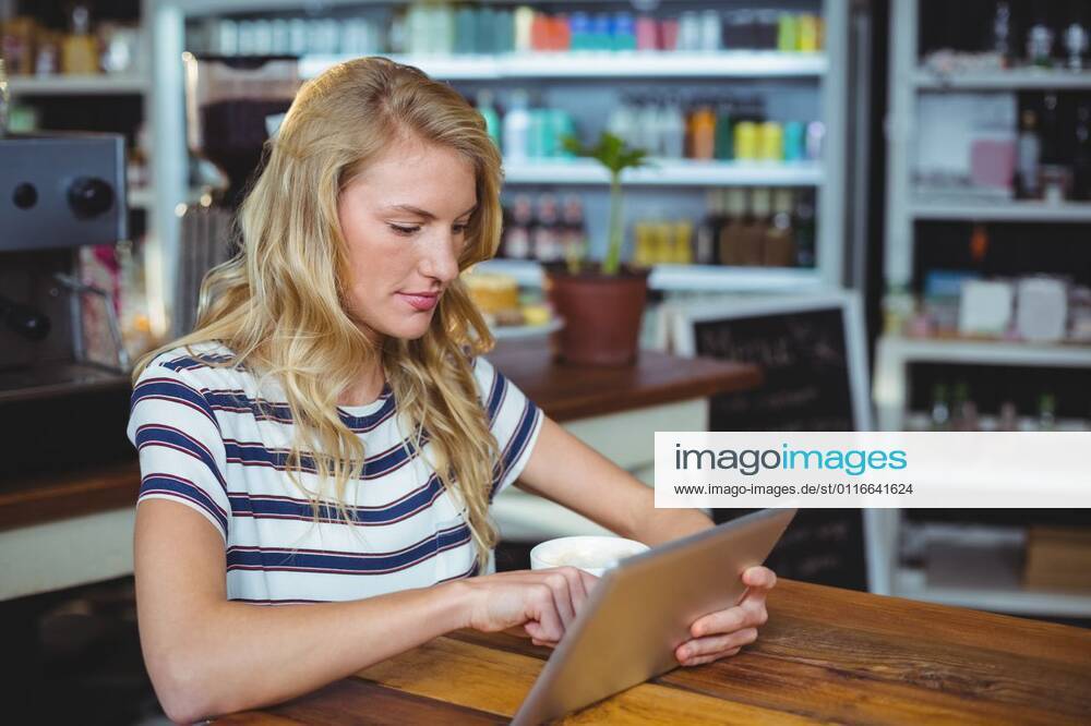 Woman sitting in a cafe using digital tablet Thoughtful woman sitting in a cafe using digital tablet, model released, , property released, Cape Town, South Africa, 30.05.2016, 797484.jpg, table, cafe, coffee shop, cafeteria, restaurant, hotel, casual clothing, sitting, holding, serious, thoughtful, web, internet, touching, reading, scrolling, digital tablet, tablet computer, tablet pc, touchscreen, wireless technology, communication, connection, lifestyle, leisure, pretty, attractive Indoors