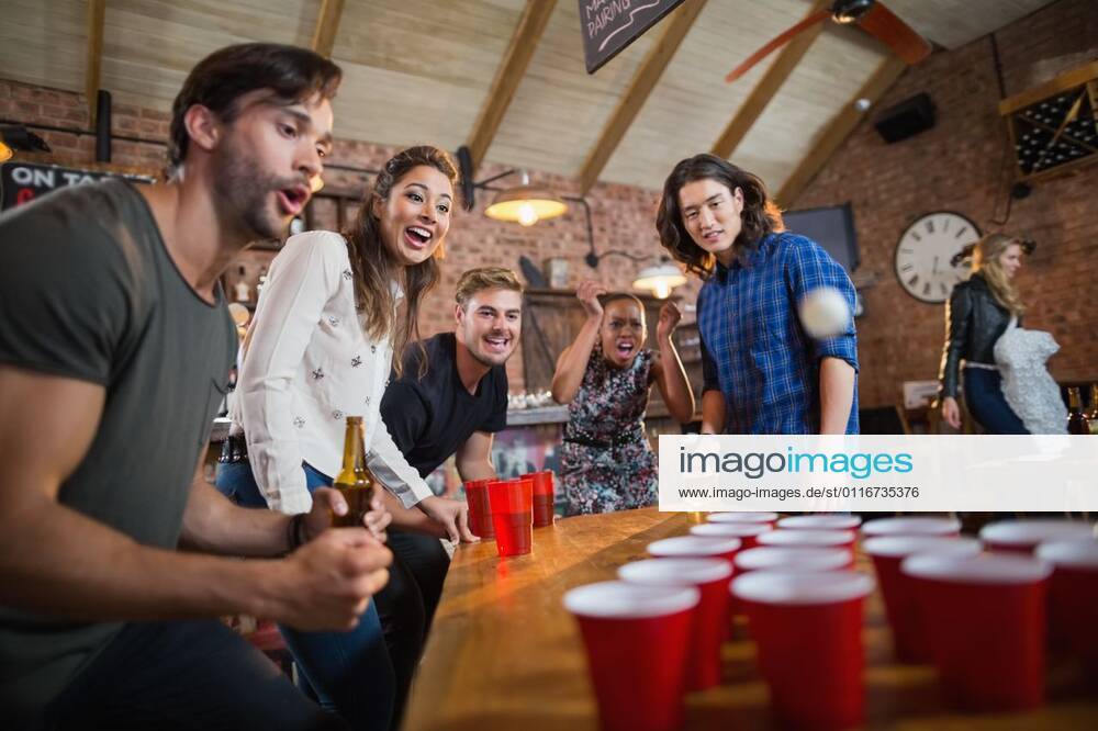 IMAGO Creative, Lifestyle, Leben in einer Wohngemeinschaft, WG Young friends enjoying beer pong game in restaurant Young friends enjoying beer pong game on table in restaurant, model released, , property released, Cape Town, South Africa, 14.11.2016, 970650.jpg, friend, enjoying, enjoyment, beer pong, game, table, restaurant, happy, playing, bar, ball, disposable cup, motion, having, drink, food and drink, refreshment, holding, alcohol, unhealthy, standing, pub, hipster, smiling, together, glass, lifestyle, leisure, casual, friendship, fun, party, togetherness, amusement, joy, pleasure, amusing, entertaining, celebration, shouting, red, ping pong, focus shot, mouth open, blurred motion, millennial Indoors