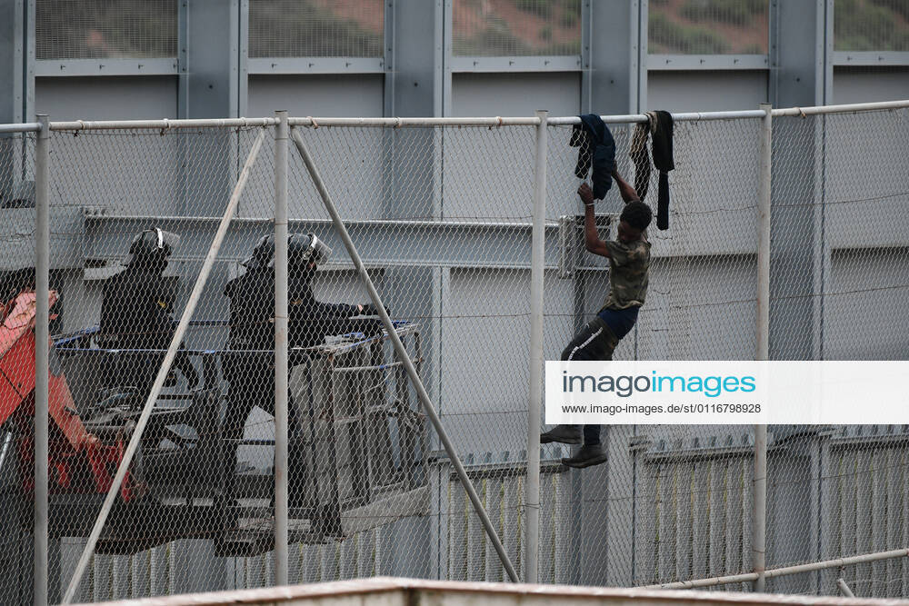 Two agents approach a migrant who tries to jump the fence that separates Ceuta from Morocco, on April 13, 2021, in Ceuta, (Spain). In the early hours of the morning of Tuesday, April 13, a group of at least 60 migrants tried to jump the fence to enter Spanish territory, a fact that has caused the intervention of agents of the Moroccan Security Forces and the Civil Guard to prevent their entry into the country. According to police sources have informed LagenciaEP , the jump has not caused any injuries and although several people have managed to climb the outer fence of the autonomous city, none has managed to access Spanish territory. 13 APRIL 2021;CEUTA;JUMPING;FENCE;MIGRANTS Antonio Sempere LagenciaEP 04 13 2021 Ceuta Ceuta Spain