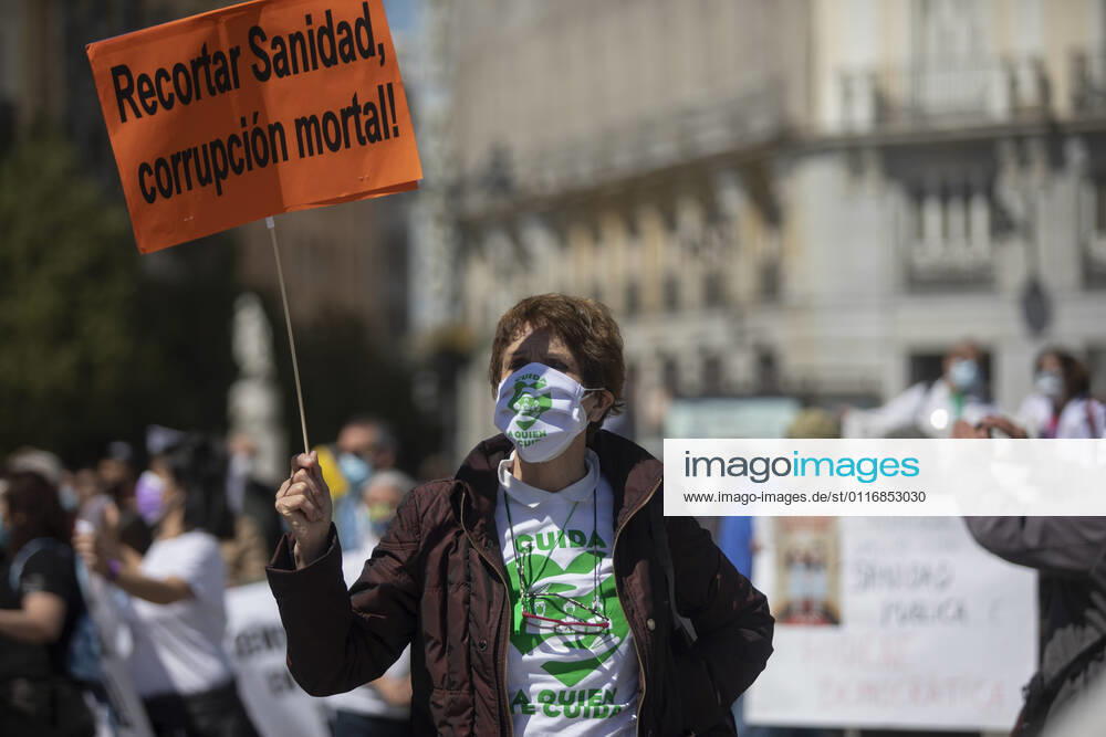 A protester holds a placard that says Health cuts, deadly corruption during the demonstration..Under the slogan Choose Public Health , various organizations and collectives, workers and users of public health demonstrate in Madrid city center (Puerta del Sol) demanding a coherent health policy due to the crisis of the Coronavirus pandemic. Madrid Spain - ZUMAs197 20210417_zaa_s197_013
