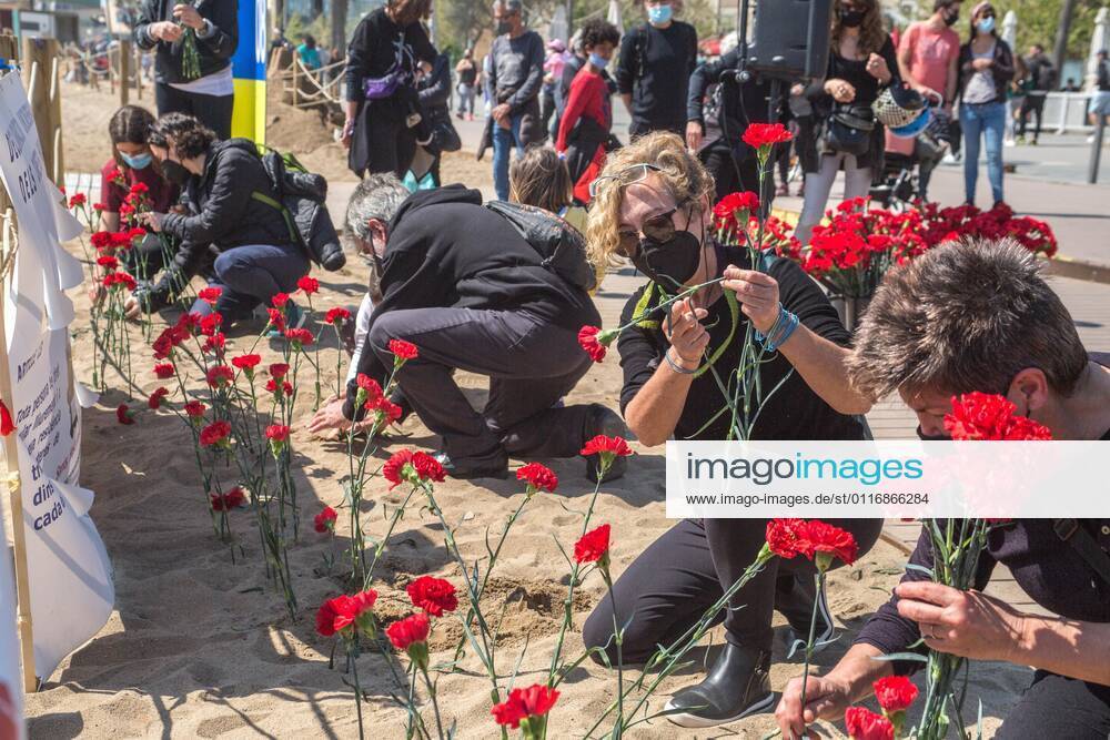People are seen putting carnation seedling on beach sand.Stop Mare Mortum, a platform that aims to promote a change in European immigration and immigration policies in order to ensure that human rights are guaranteed and respected, has carried out, on Barceloneta beach in Barcelona, an visual action to denounce the constant deaths in the Mediterranean and the Atlantic. Some 150 people have carried out a carnation planting on behalf of the more than 1200 people who died during 2020 on the route to reach the Canary Islands. Barcelona Spain - ZUMAd159 20210418_zia_d159_001