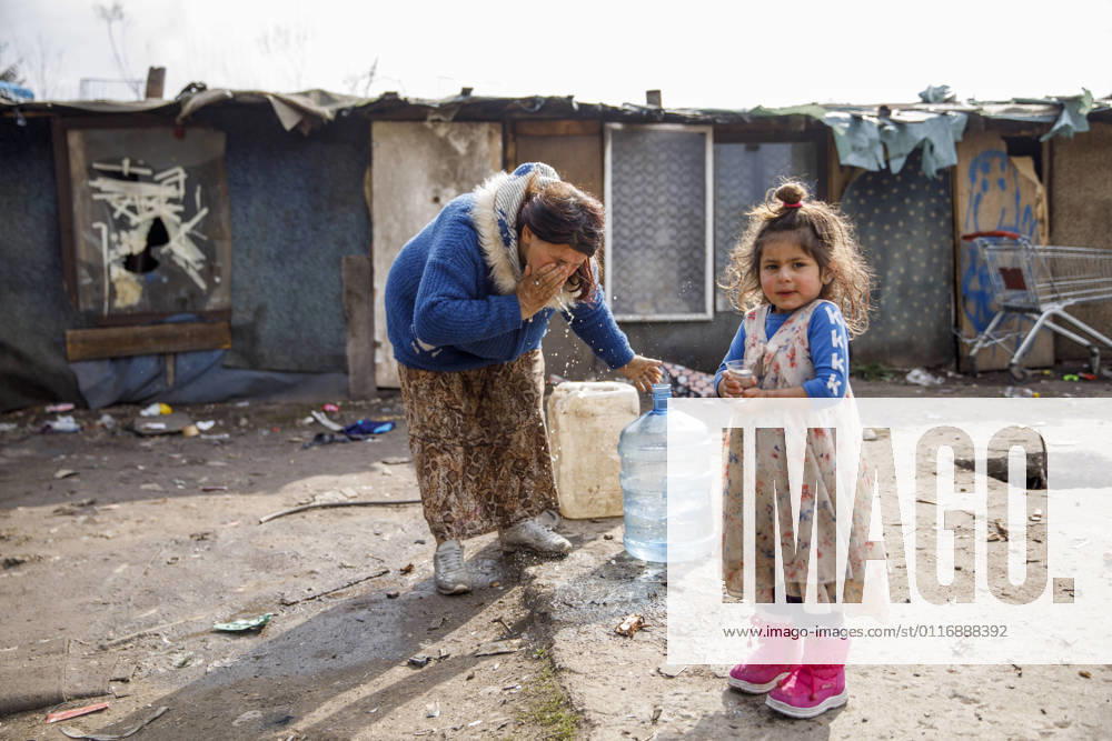 PXL_The municipality of Ilidza plans to demolish the Roma settlement The mother washes herself with a bottle of water next to a girl with a glass of water in a Roma settlement in Sarajevo, Bosnia and Herzegovina on April 20, 2021. The municipality of Ilidza has ordered the demolition of the barracks where more than 60 Roma live, including 40 children. The inspection ordered the removal of the illegal settlement, without offering alternative accommodation. Human rights activists warn that the latest case is just a reflection of decades of neglect. This settlement has existed for 12 years. ArminxDurgut PIXSELL