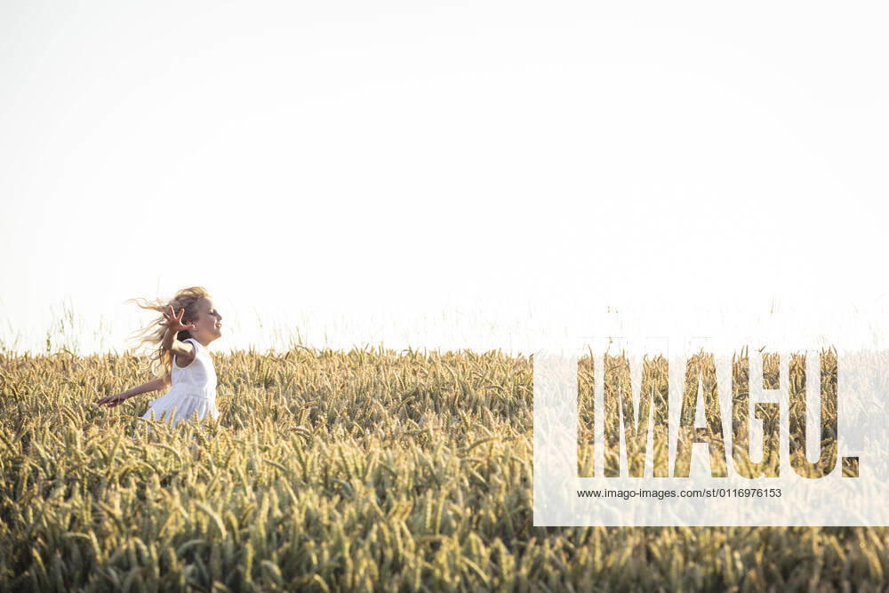 IMAGO Creative: 2021 Favoriten IMAGO Creative: Klimawandel - Zukunft und Innovation Girl with tousled hair running through agricultural field during sunset model released Symbolfoto WFF00521
