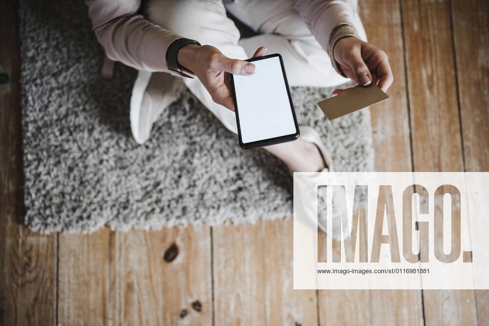 Hands of woman holding smart phone and credit card at home model released Symbolfoto property released EBBF02899