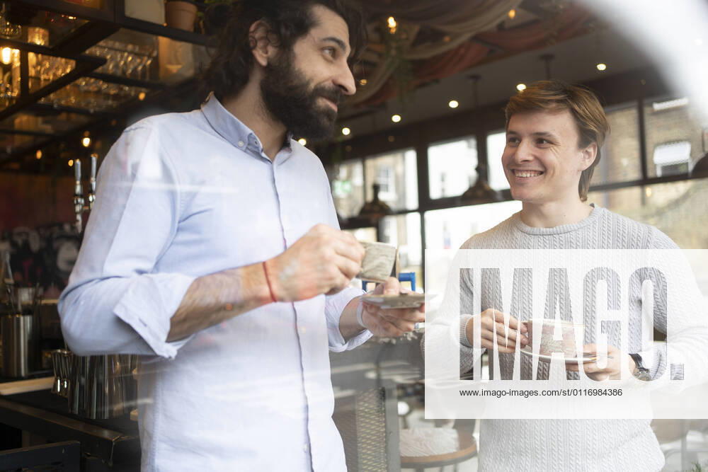 Male coworkers having coffee during break time at office model released Symbolfoto property released FBAF01689