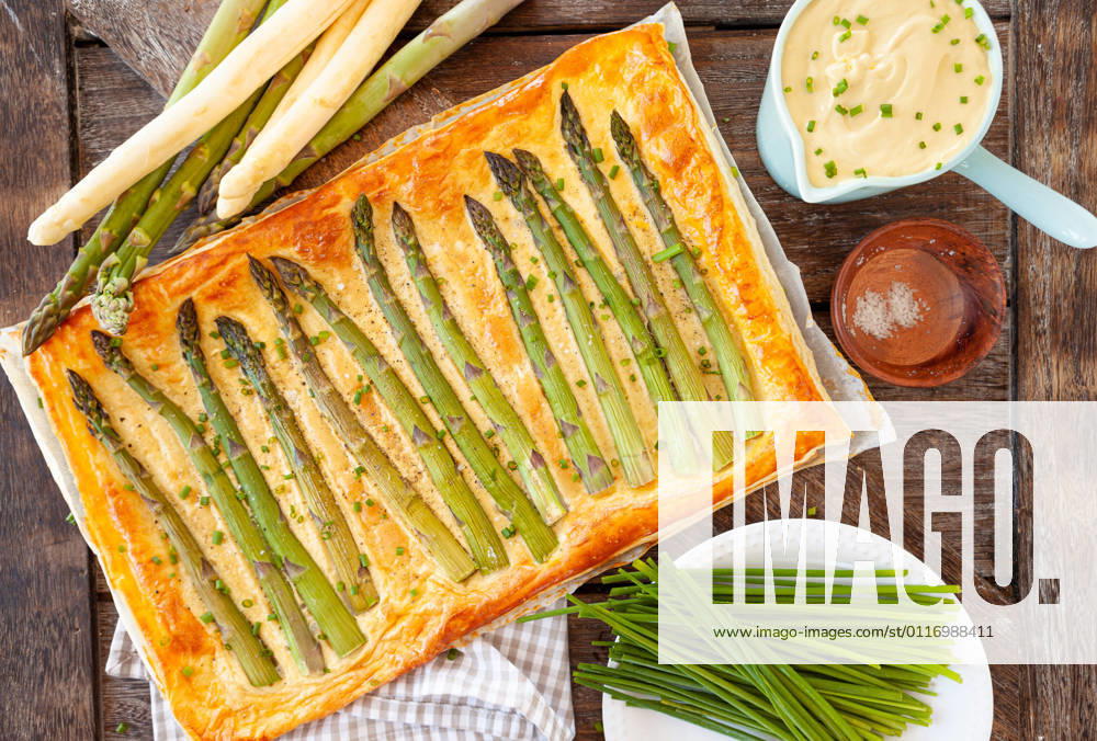 Hearty puff pastry quiche with green asparagus 1079706590