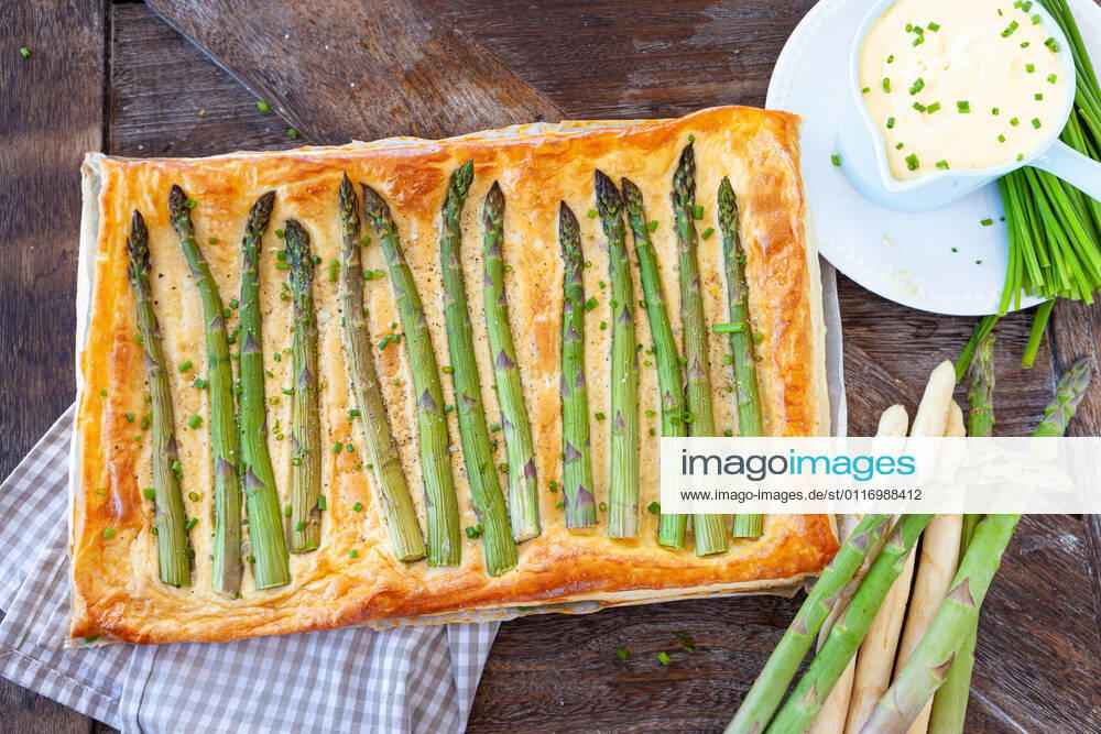 Hearty puff pastry quiche with green asparagus 1079706591