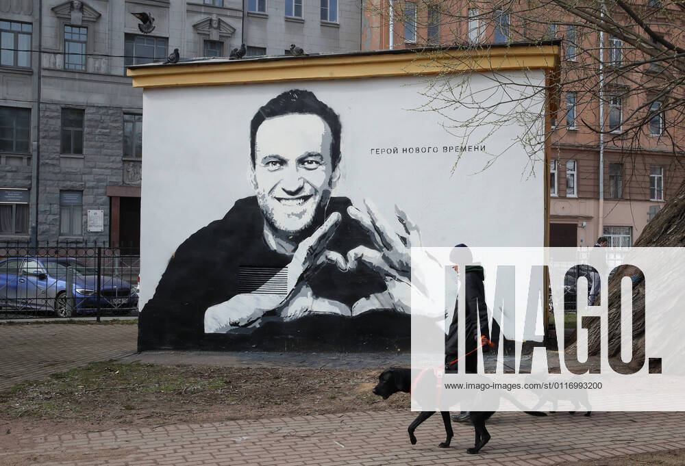 Bilder des Jahres 2021, News 04 April ST PETERSBURG, RUSSIA - APRIL 28, 2021: A woman and dogs walk by a mural depicting Russian opposition activist Alexei Navalny and reading The hero of new times on a transformer house in Pushkarsky Garden. The mural was discovered in the early morning of April 28 and painted over around 10:30 am. Alexander Demianchuk TASS TS0FE4A9
