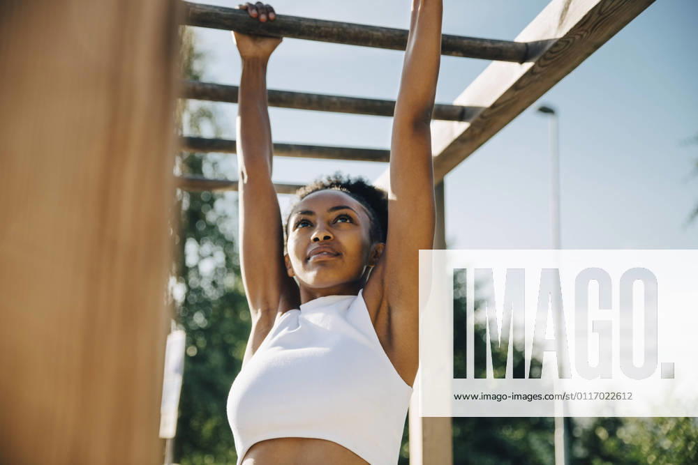 IMAGO Creative, Lifestyle, Tik Tok-Trend thatgirl Female athlete hanging on monkey bar in park Sweden, Stockholm, model released
