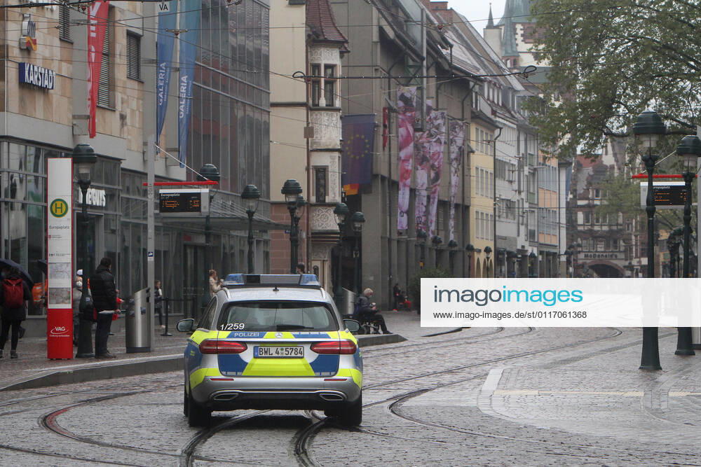 A police patrol of the state police of Baden Württemberg drives through the almost deserted pedestrian zone and shopping street Kaiser Joseph Straße in the city center of Freiburg, Baden Württemberg, Bavaria, Germany.