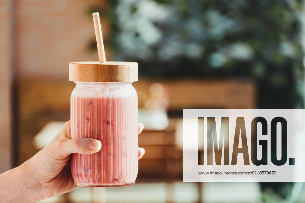Young woman s hand with a red fruit smoothie. Barcelona, CT, Spain CR_XAJU210520-750792-01