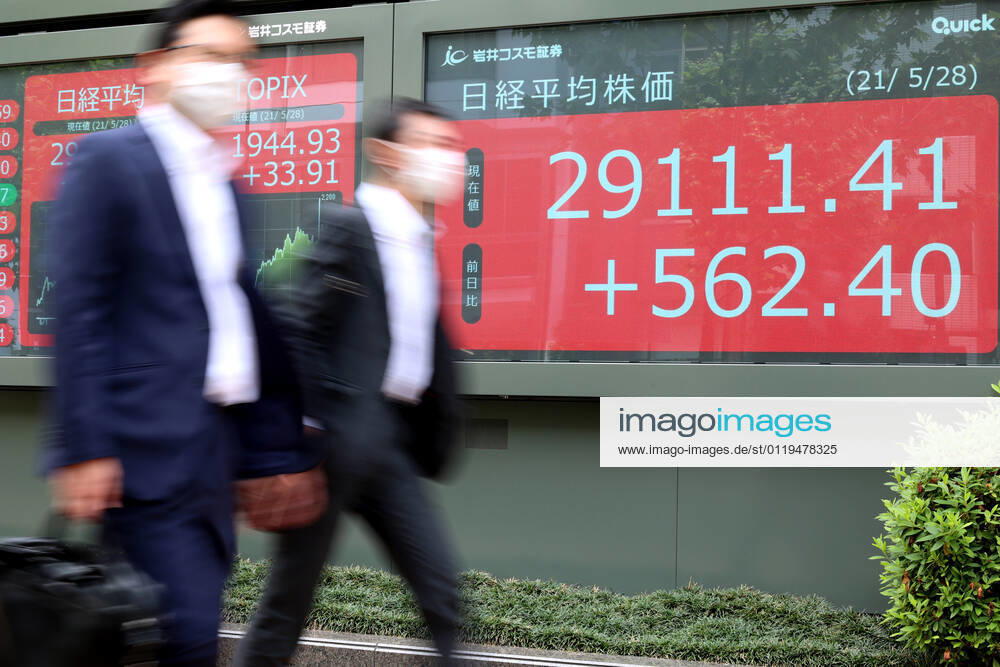 Tokyo, Japan - Pedestrians pass before a share prices board in Tokyo on Friday, May 28 2021. Japan s share prices rose 562.40 yen to close at 29,111.41 yen at the morning session of the Tokyo Stock Exchange as hopes grew for a U.S. economic recovery. (161307913)