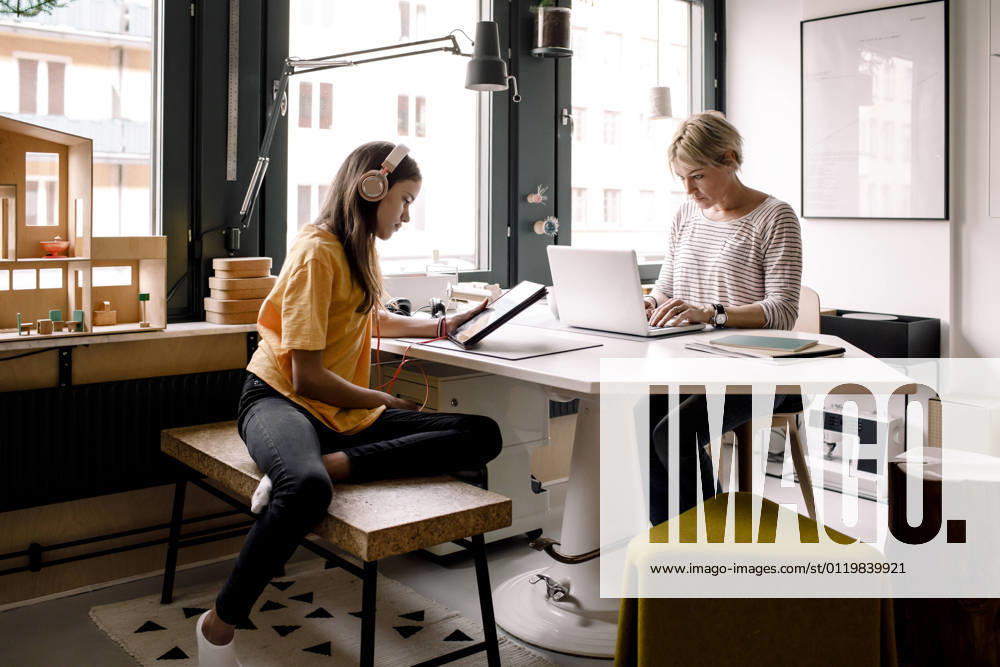 Businesswoman working while daughter learning through digital tablet at home Sweden, Stockholm, model released, property released