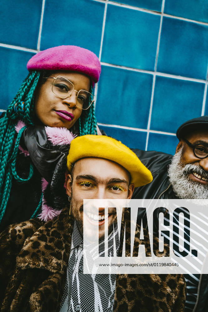 Portrait of smiling young man with friends wearing berets Berlin, Germany, model released