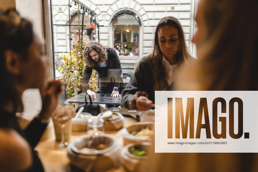 IMAGO Creative: Kollidierende Kulturen IMAGO Creative: Kimawandel - Weihnachten, Weihnachtsessen vegan IMAGO Creative: Kreative Renaissance -- der junge Entrepreneur Multi-ethnic female friends having food in restaurant while waiter cleaning table outside Sweden, Gothenburg, model released, property released