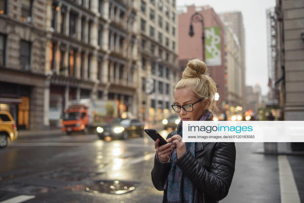Attractive woman using smartphone on busy urban street New York, NY, United States CR_OSBJ210603-695036-01 ,model released, Symbolfoto