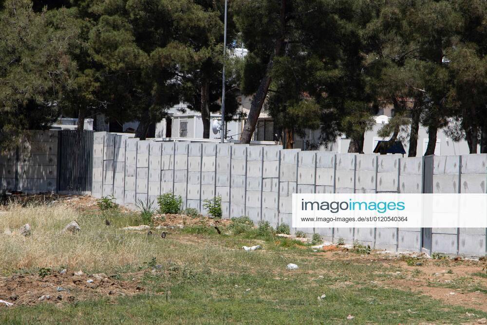 New Concrete Walls Around Diavata Refugee Camp In Greece Greece is building new concrete walls around the refugee camps across the country in the mainland and the islands. The 3meter wall was a decision by the Greek Ministry of Migration and European Commission. Asylum seekers feel like imprisonment conditions while the authorities claim its for their own security, monitoring the entrance and locking the camp during the night. Diavata refugee and migrant camp is a former military camp near the city of Thessaloniki in Northern Greece. The concrete fortification called enhanced fence has been built around the whole area of the camp. Diavata, Greece on June 6, 2021 Thessaloniki Greece economou-notitle210605_npl1K