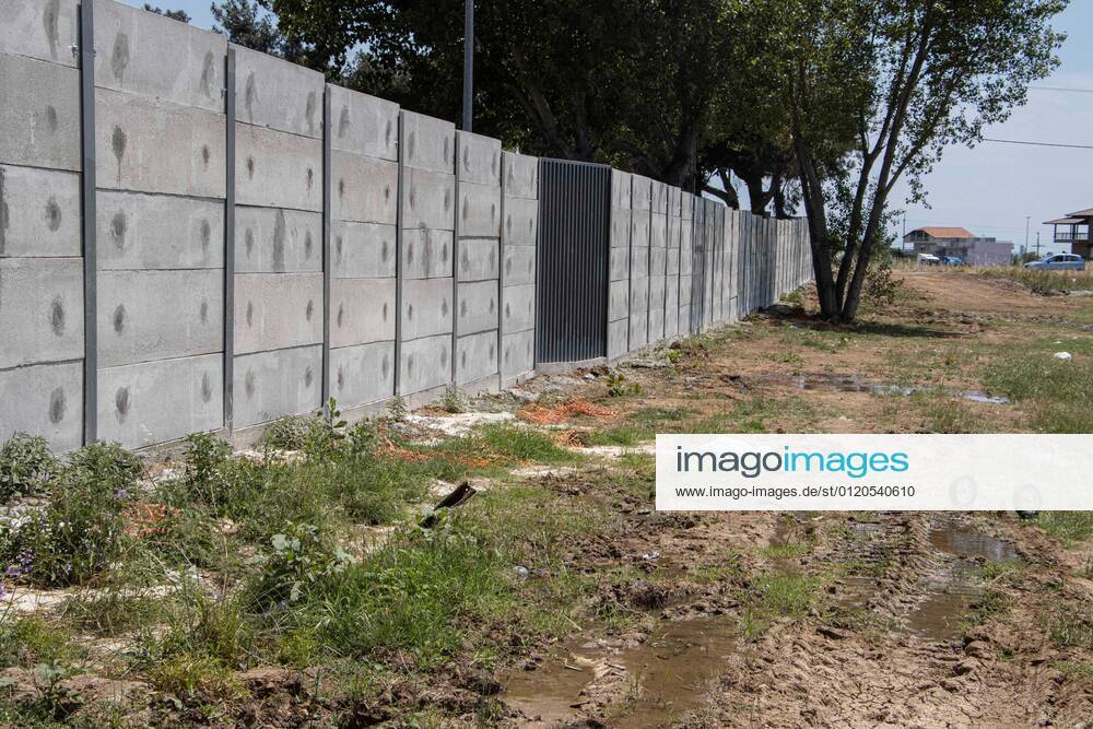 New Concrete Walls Around Diavata Refugee Camp In Greece Greece is building new concrete walls around the refugee camps across the country in the mainland and the islands. The 3meter wall was a decision by the Greek Ministry of Migration and European Commission. Asylum seekers feel like imprisonment conditions while the authorities claim its for their own security, monitoring the entrance and locking the camp during the night. Diavata refugee and migrant camp is a former military camp near the city of Thessaloniki in Northern Greece. The concrete fortification called enhanced fence has been built around the whole area of the camp. Diavata, Greece on June 6, 2021 Thessaloniki Greece economou-notitle210605_npu60