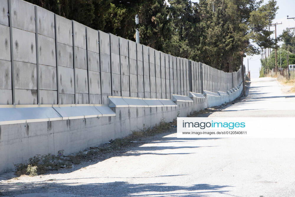 New Concrete Walls Around Diavata Refugee Camp In Greece Greece is building new concrete walls around the refugee camps across the country in the mainland and the islands. The 3meter wall was a decision by the Greek Ministry of Migration and European Commission. Asylum seekers feel like imprisonment conditions while the authorities claim its for their own security, monitoring the entrance and locking the camp during the night. Diavata refugee and migrant camp is a former military camp near the city of Thessaloniki in Northern Greece. The concrete fortification called enhanced fence has been built around the whole area of the camp. Diavata, Greece on June 6, 2021 Thessaloniki Greece economou-notitle210605_npypL