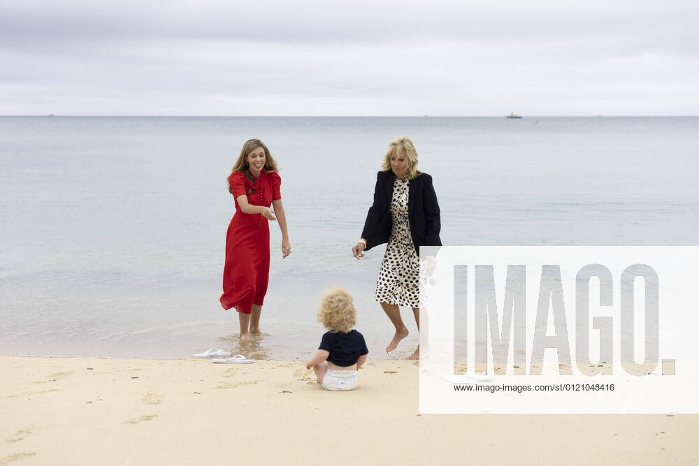 Carrie Johnson, the wife of Prime Minister Boris Johnson, speaks with First Lady of the United States Dr. Jill Biden as Wilfred Johnson sits on the beach during the G7 Leaders Summit in Carbis Bay, Cornwall, United Kingdom, on June 10, 2021. WAX2021061004 SIMONxDAWSON