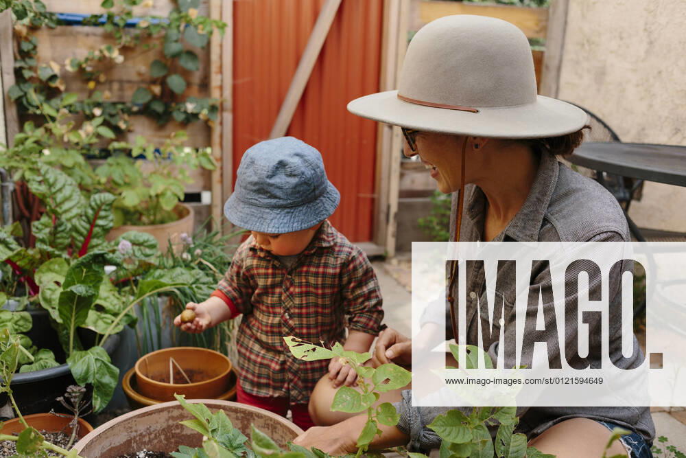 IMAGO Creative: Klimawandel - Zukunft und Innovation Mother looking at toddler boy in back yard garden model released Symbolfoto property released ACTF00018