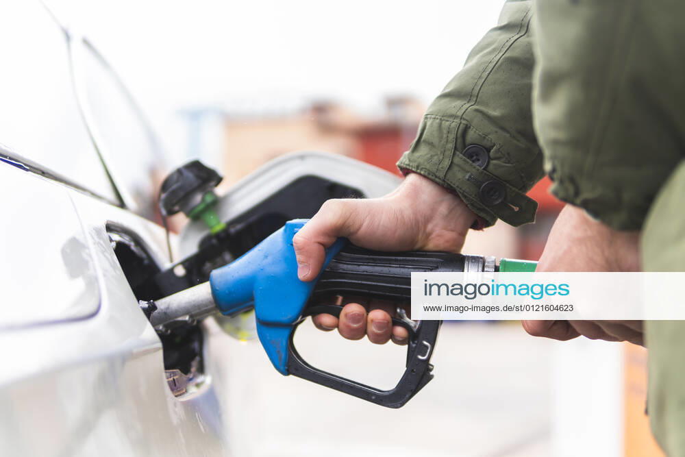 Man refueling car at gas station model released Symbolfoto property released JAQF00500