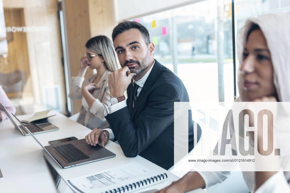 Businessman working with female coworkers in office model released Symbolfoto property released JSRF01514