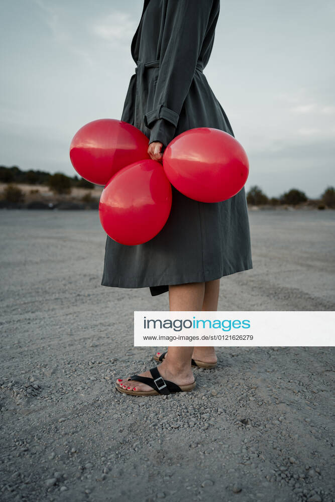 Woman holding balloon while standing at road model released Symbolfoto RCPF01006