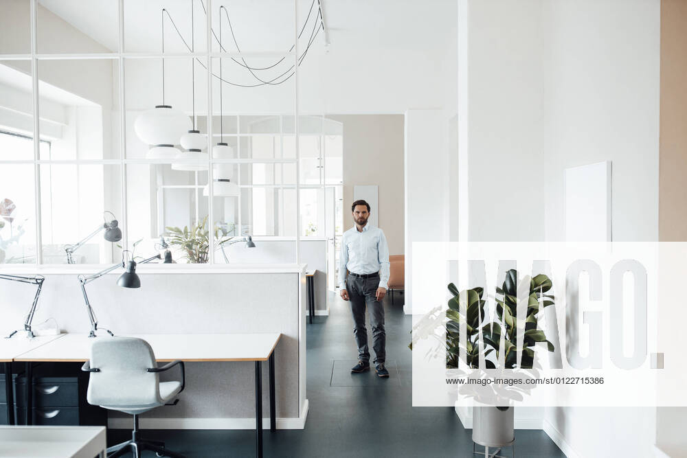 Male entrepreneur staring while standing in office model released Symbolfoto property released GUSF06026