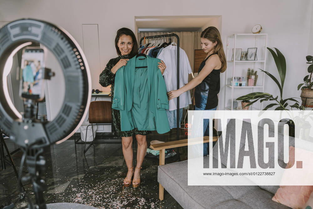 IMAGO Creative: Digitale Welt, Social Commerce Female fashion influencers showing dresses while filming at home model released Symbolfoto property released MFF08094