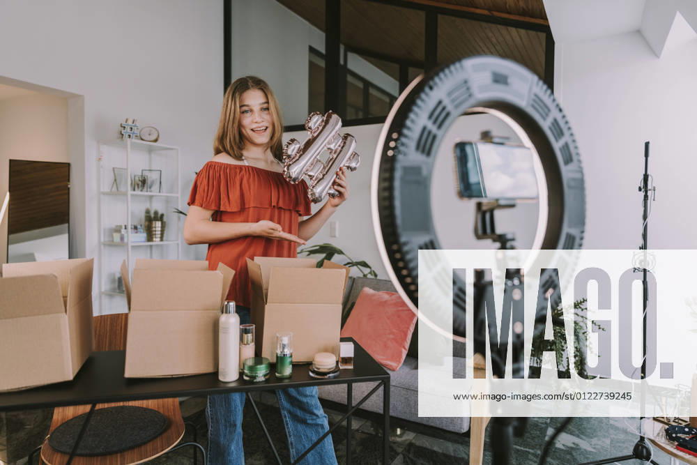 Teenage girl holding hashtag sign and filming at home model released Symbolfoto property released MFF08168