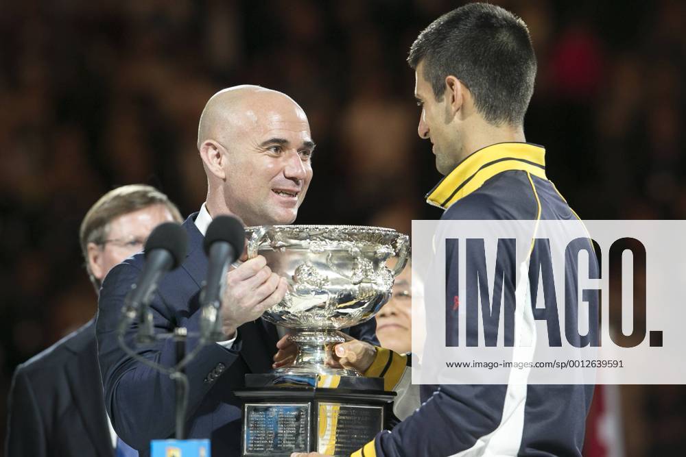 Andre Agassi hands the winners trophy to Novak Djokovic during Day 14 of the Mens final at Rod Laver Arena at the Australian Tennis open Grand Slam event at Melbourne Park, Melbourne Australia. TENNIS: JAN 27 Australian Open Icon1301270155