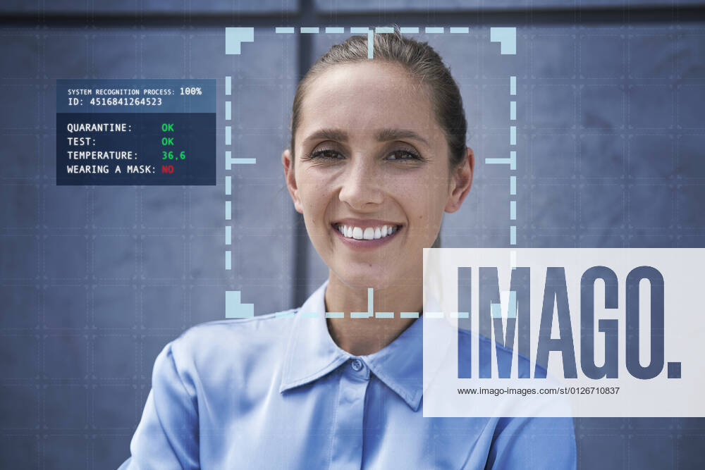 Smiling businesswoman with facial recognition technology in front of wall model released Symbolfoto property released ABIF01402
