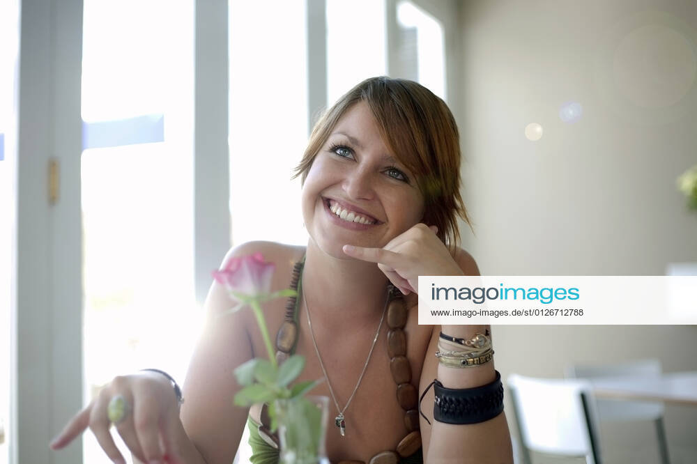 Happy young woman gesturing call me sign at restaurant model released Symbolfoto property released AJOF01519