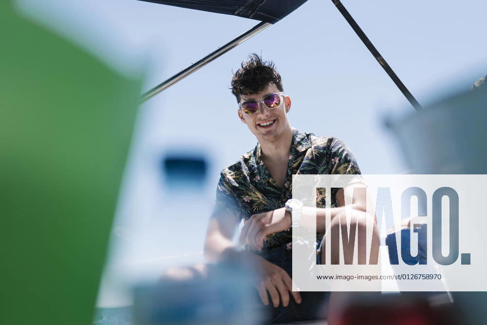 Smiling handsome man sitting on yacht during vacation model released Symbolfoto EGAF02454