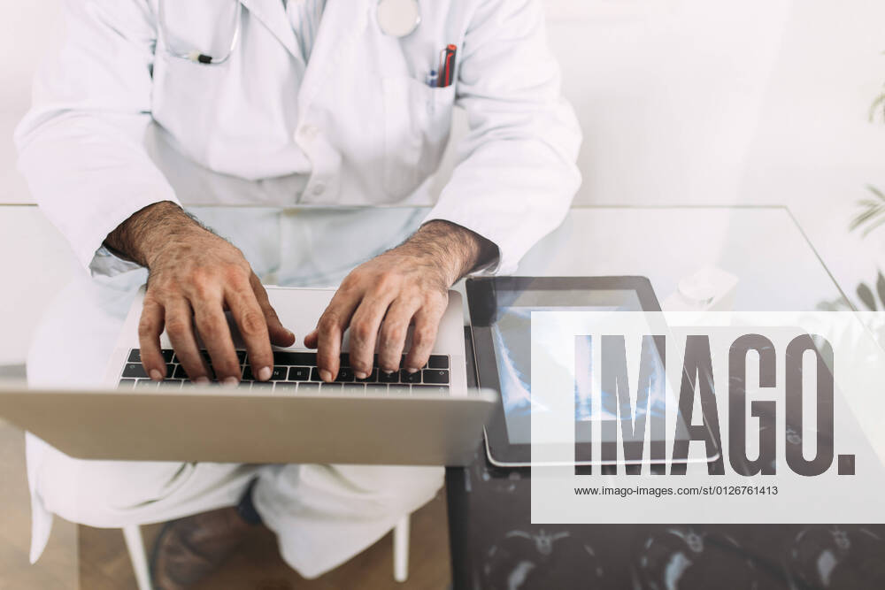 Senior male doctor working on laptop at desk in clinic model released Symbolfoto property released EGHF00042