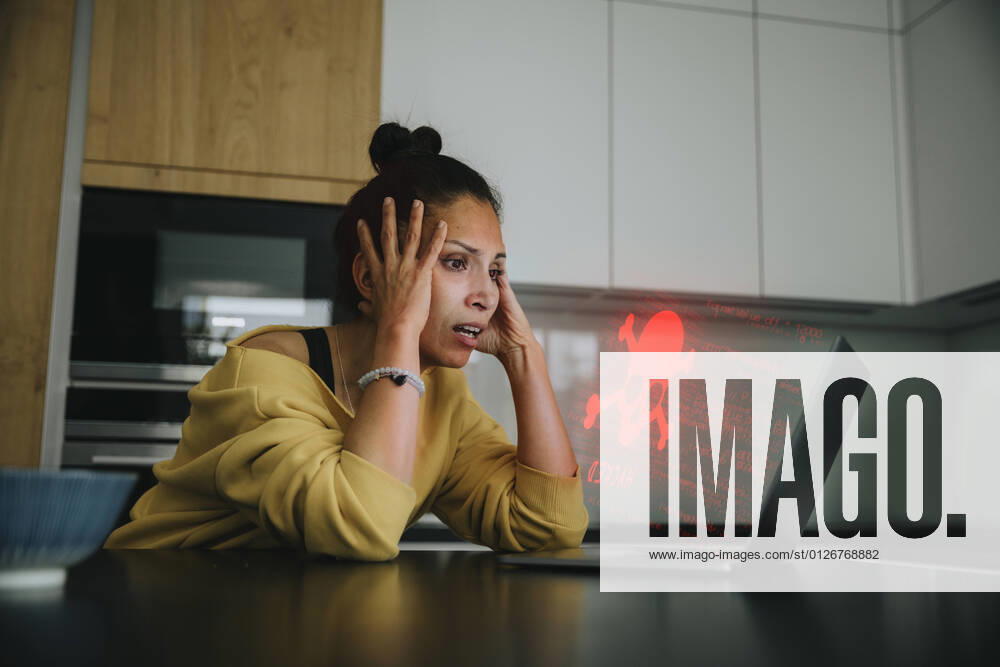 Woman with head in hands looking at danger icon laptop model released Symbolfoto property released LIFIF00047