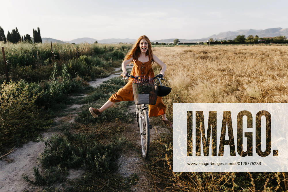 Carefree woman riding bicycle in agricultural field model released Symbolfoto TCEF01965