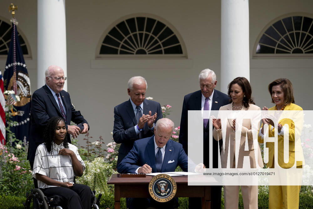 Tyree Brown, from left, Senator Patrick Leahy, a Democrat from Vermont, former Representative Tony Coelho, House Majority Leader Steny Hoyer, a Democrat from Maryland, U.S. Vice President Kamala Harris, and Speaker of the House Nancy Pelosi, a Democrat from California, applaud as U.S. President Joe Biden, center, signs a proclamation during an event marking the 31st anniversary of the Americans with Disabilities Act (ADA) in the Rose Garden of the White House in Washington, D.C., U.S., on Monday, July 26, 2021. The Biden administration is keeping foreign travel restrictions in place amid concern about rising Covid-19 case levels as the delta variant spreads. WASP20210726110 StefanixReynolds