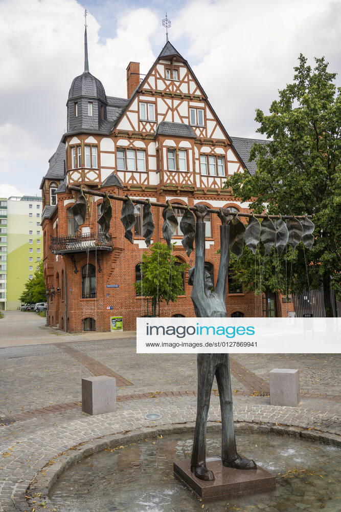 The tobacco fountain by the artist Jan Witte Kropius on the Vierradener Platz in Schwedt Oder district of Uckermark The fountain shows a worker hanging tobacco to dry A little devil leans against a seat and smokes a pipe Photo Volker Hohlfeld The tobacco fountain in Schwedt Oder