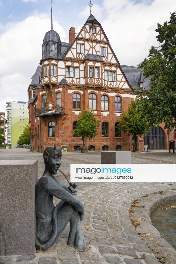 The tobacco fountain by the artist Jan Witte Kropius on the Vierradener Platz in Schwedt Oder district of Uckermark The fountain shows a worker hanging tobacco to dry A little devil leans against a seat and smokes a pipe Photo Volker Hohlfeld The tobacco fountain in Schwedt Oder