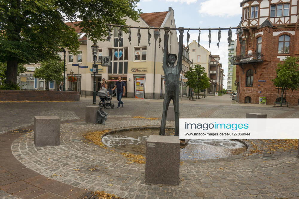 The tobacco fountain by the artist Jan Witte Kropius on the Vierradener Platz in Schwedt Oder district of Uckermark The fountain shows a worker hanging tobacco to dry A little devil leans against a seat and smokes a pipe Photo Volker Hohlfeld The tobacco fountain in Schwedt Oder
