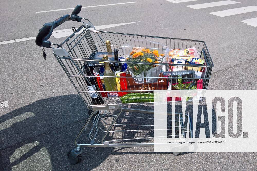 Food shopping, shopping cart with food at supermarket parking lot, stocked with flowers, food food theme spending or cost of living