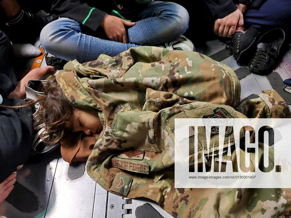 An Afghan child sleeps on the cargo floor of a U.S. Air Force C-17 Globemaster III, kept warm by the uniform of a United States Air Force member during an evacuation flight from Kabul, Afghanistan. Evacuations from Kabul s Hamid Karzai International Airport continued as foreigners and Afghans scrambled to get out of the country now under control of the Taliban. Kabul Afghanistan - ZUMA7-41 20210818_int_z03_010